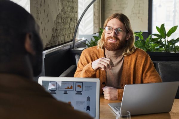 smiling-bearded-man-discussing-project-at-cafe-tab-2021-09-24-04-17-29-utc